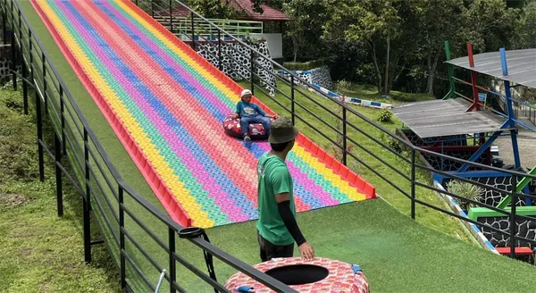 Merasakan sensasi meluncur di Rainbow Slide Bhakti Alam yang warna-warni dan seru