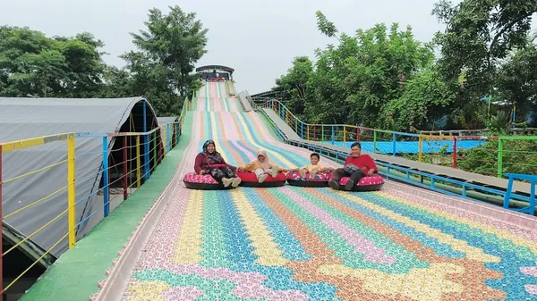Keceriaan siswa sekolah saat mencoba wahana rainbow slide yang memacu adrenalin