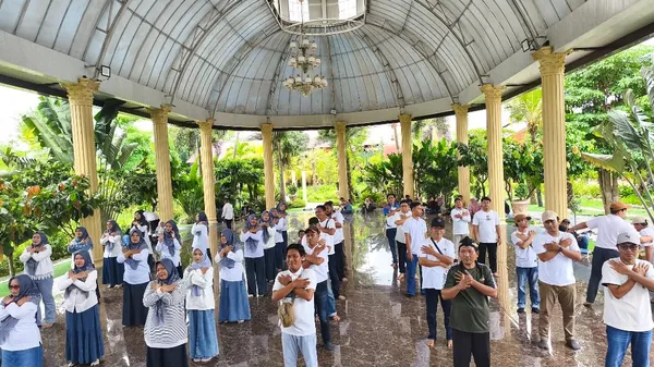 Instruktur Nila Productions memandu pemanasan sebelum kegiatan outbound dimulai